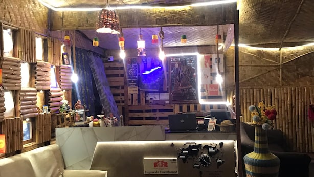 Un intérieur chaleureux avec un plafond en bois, un comptoir d’accueil, un canapé et un vase décoratif.