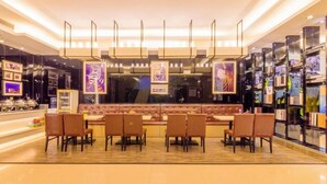 Um restaurante moderno com um balcão extenso, diversas cadeiras e obras de arte emolduradas nas paredes.