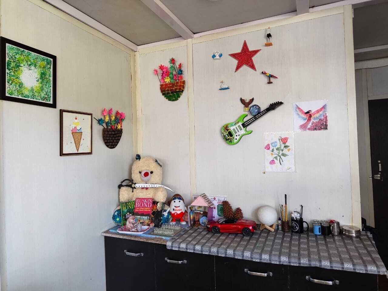 A room with a desk, various decorations, and a teddy bear.