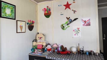 A room with a desk, various decorations, and a teddy bear.