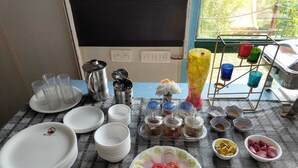 A table with plates, bowls, and condiments. - Nisarg Camping Pods (Almora)