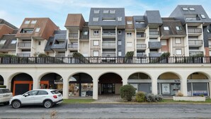 Un moderno edificio de apartamentos con varios balcones y un patio central.