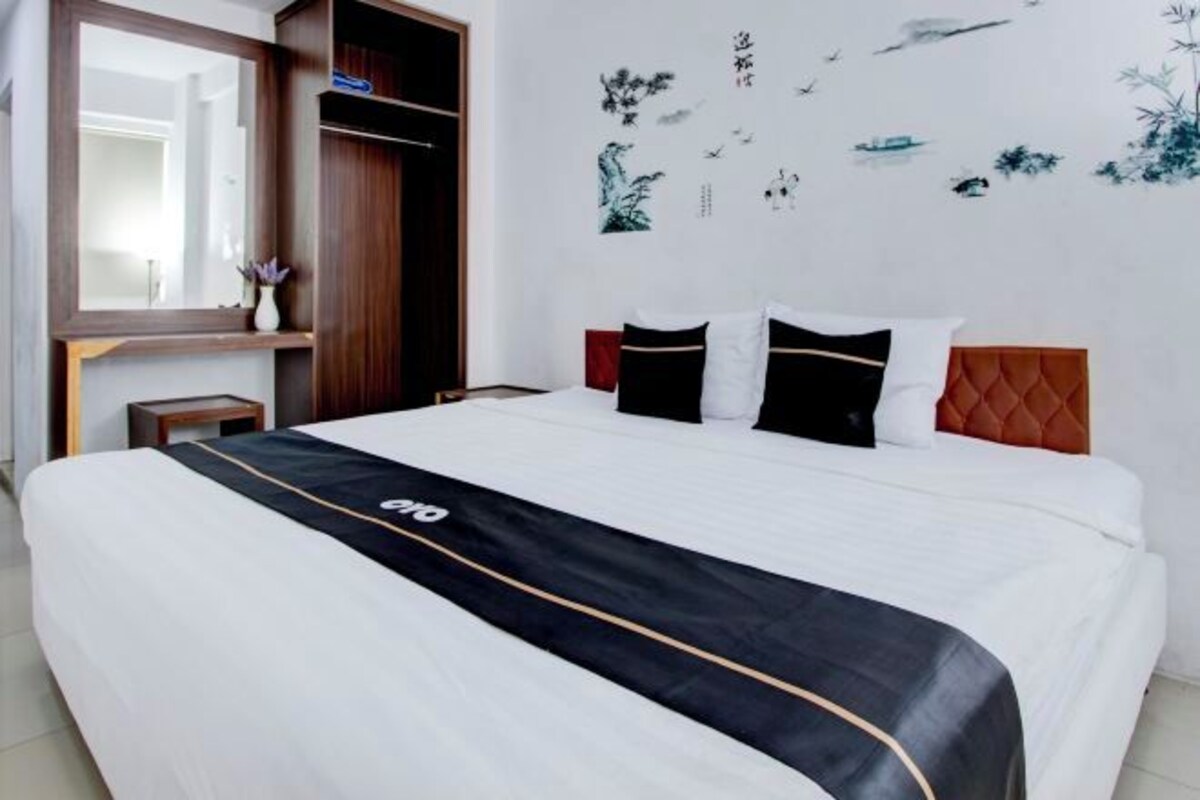 Une chambre d’hôtel équipée d ’un lit, d’une armoire, d’un miroir et de décorations murales.