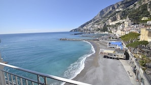 A coastal town with buildings along the beach, a rocky cliff, and a clear blue sea. - Appartamento Attilia B: A graceful apartment which faces the sun and the sea, with Free WI-FI. (Amalfi)