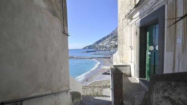 A narrow stairway leading to a beach with a view of the sea and a building with a green door. - Appartamento Attilia B: A graceful apartment which faces the sun and the sea, with Free WI-FI. (Amalfi)