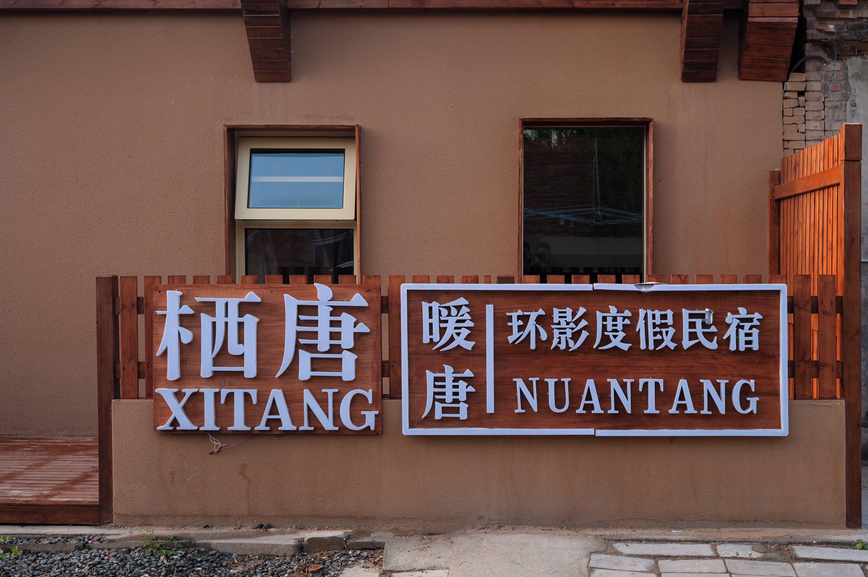 Um edifício com uma placa que diz 'XITANG' e 'NUANTANG' em chinês e inglês.