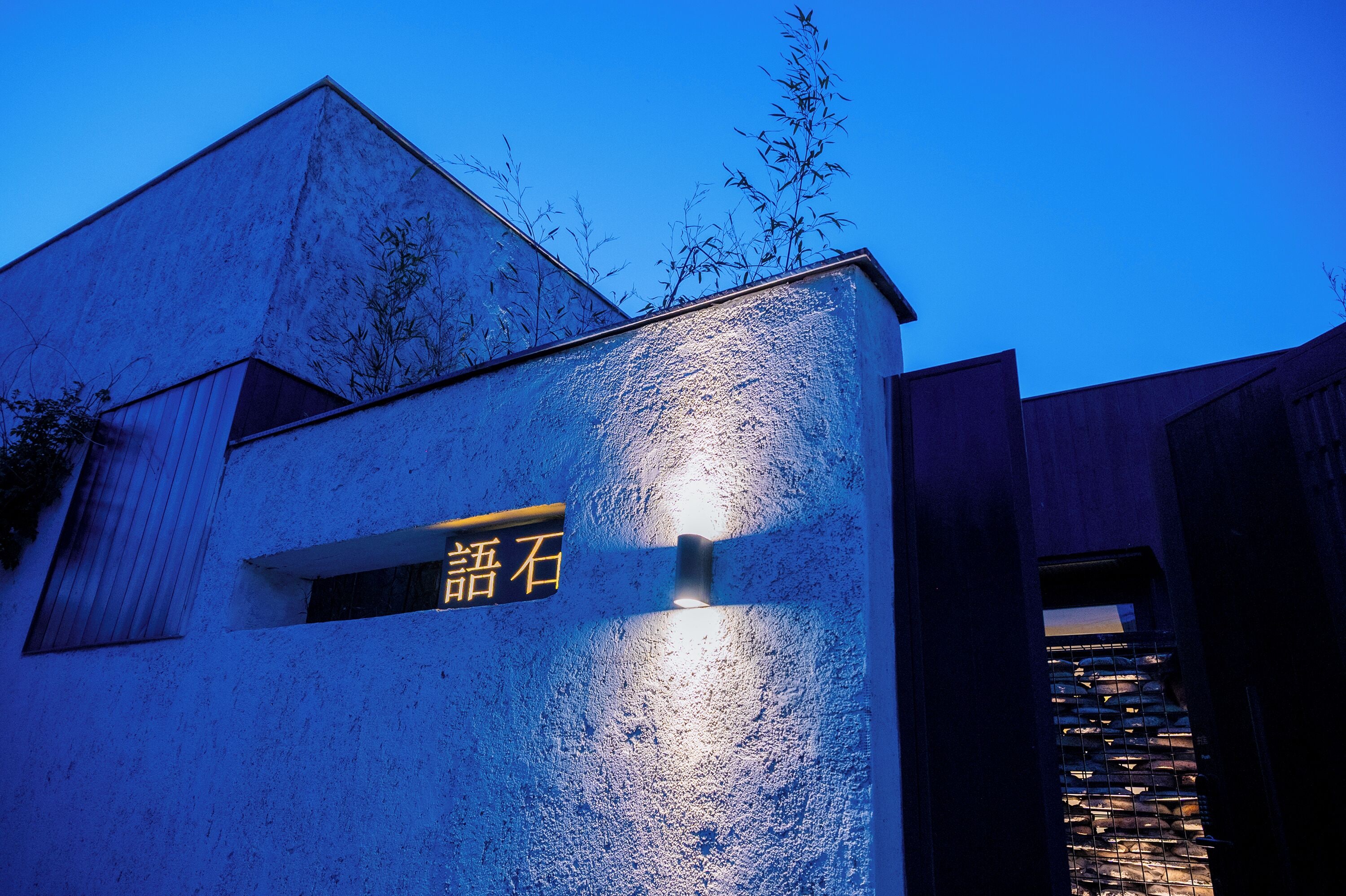 Un bâtiment doté d’une façade à motifs, une fenêtre avec une enseigne et un ciel d’un bleu éclatant.
