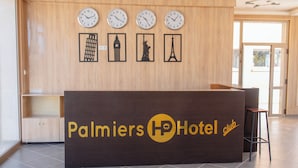 A reception desk with clocks and silhouettes of famous landmarks. - Palmiers Hôtel Club (Errachidia)