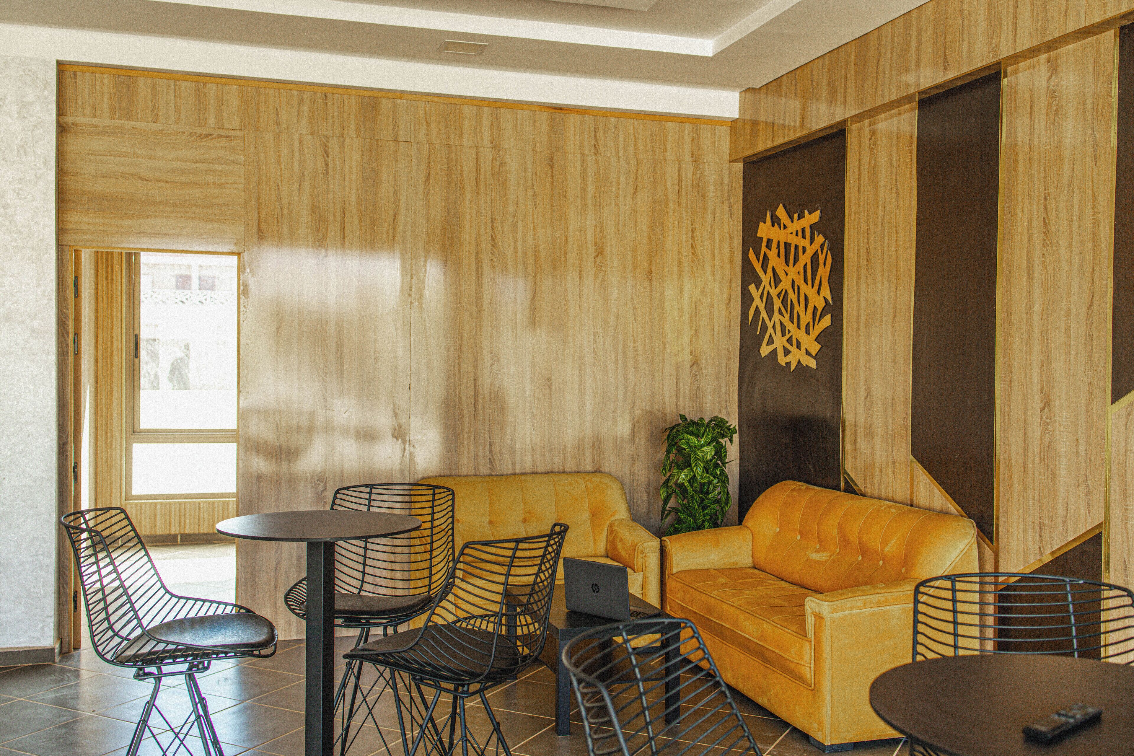 A modern living room with a sofa, chairs, a coffee table, and a laptop.