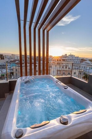 Un jacuzzi en un balcón con vista a la ciudad.