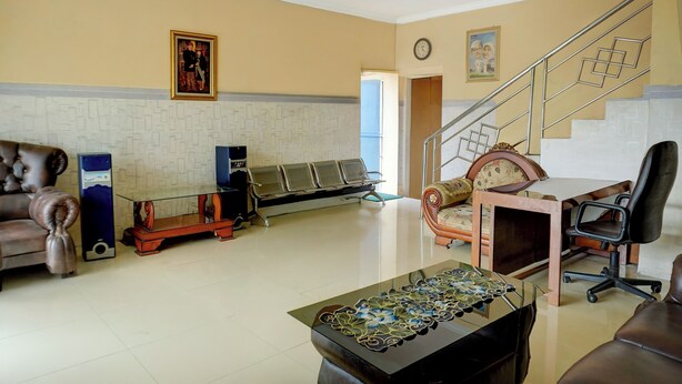 Un salón amplio con un sofá, una mesa de centro de cristal, un banco de madera y una escalera.