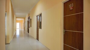 Un pasillo con puertas numeradas 103, 104 y 105, que dan a habitaciones.
