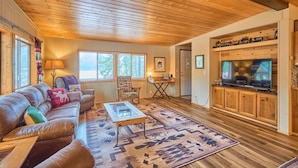 A cozy living room with a leather sofa, a coffee table, and a television on a wooden cabinet.