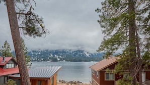 A cabin with a view of a lake and mountains.