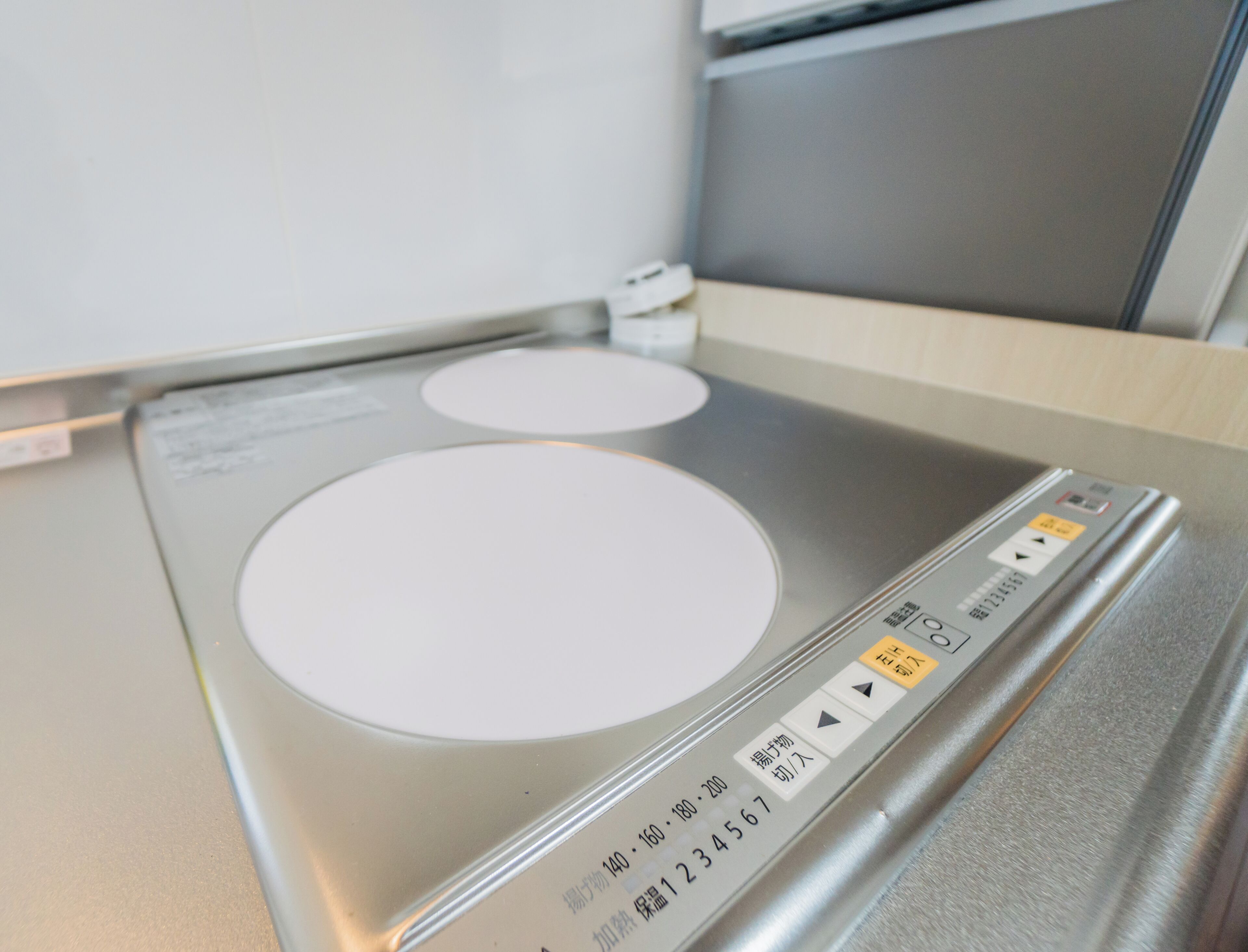 A kitchen with a built-in induction cooktop and a microwave.