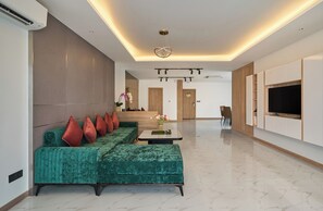 Habitación triple superior, vista a la ciudad | Área de sala de estar