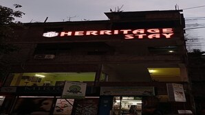 Un bâtiment orné d’une enseigne au néon sur laquelle on peut lire : « HERITAGE STAY ».