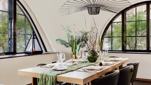 A dining area with a long table set for four, surrounded by large windows offering a view of trees. - TiPToP Oxford St! Family+Couples Unique Chill Design Haven (London)