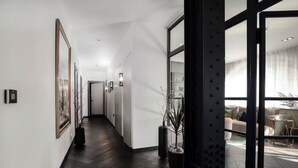 A modern hallway with dark wooden flooring, white walls, and large windows. - TiPToP Oxford St! Family+Couples Unique Chill Design Haven (London)
