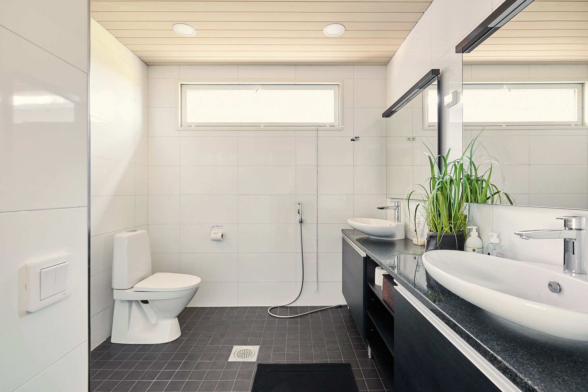 A modern bathroom with a toilet, bidet, and sink.