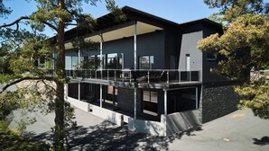 Ein modernes Gebäude mit flachem Dach, großen Fenstern und einem Balkon.