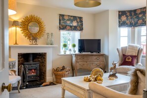 A cozy living room with a fireplace, a television, and a comfortable seating area. - Park Cottage (Glaston)