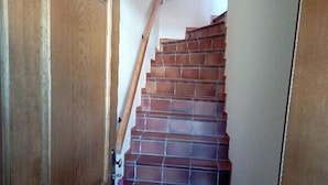 Eine Treppe mit roten Fliesen, die zu einer Zwischenebene führt.