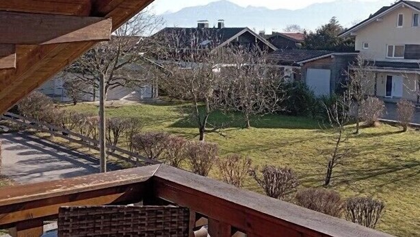 Ein Wohngebiet mit Häusern, einem Rasen und Bergen im Hintergrund.