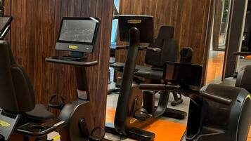 A gym with exercise equipment, a treadmill, and a mirrored wall.