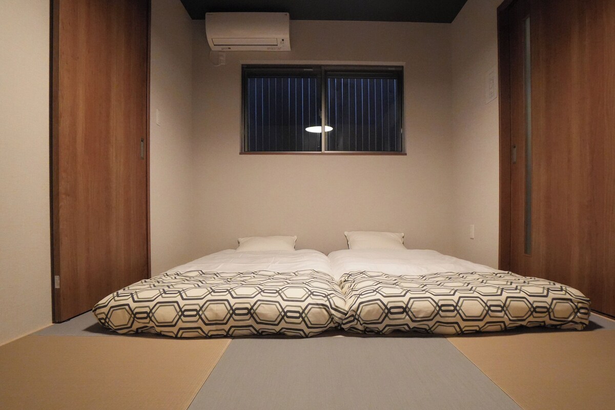 Quarto com cama, duas almofadas, janela e ar-condicionado.