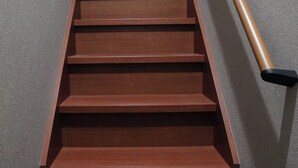 Eine Holztreppe mit Handlauf, die nach oben führt.