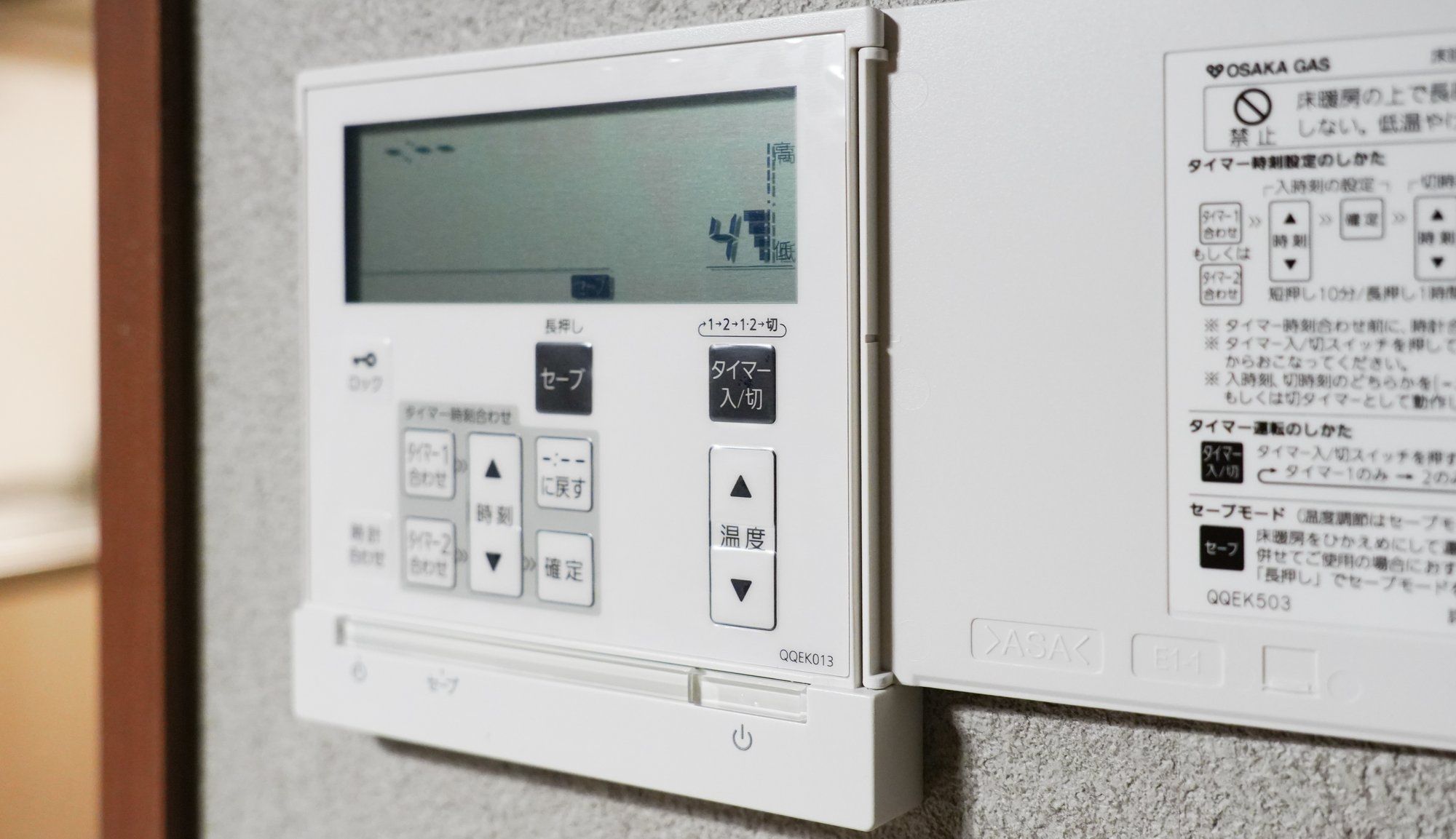 A thermostat with temperature adjustment buttons and a digital display.