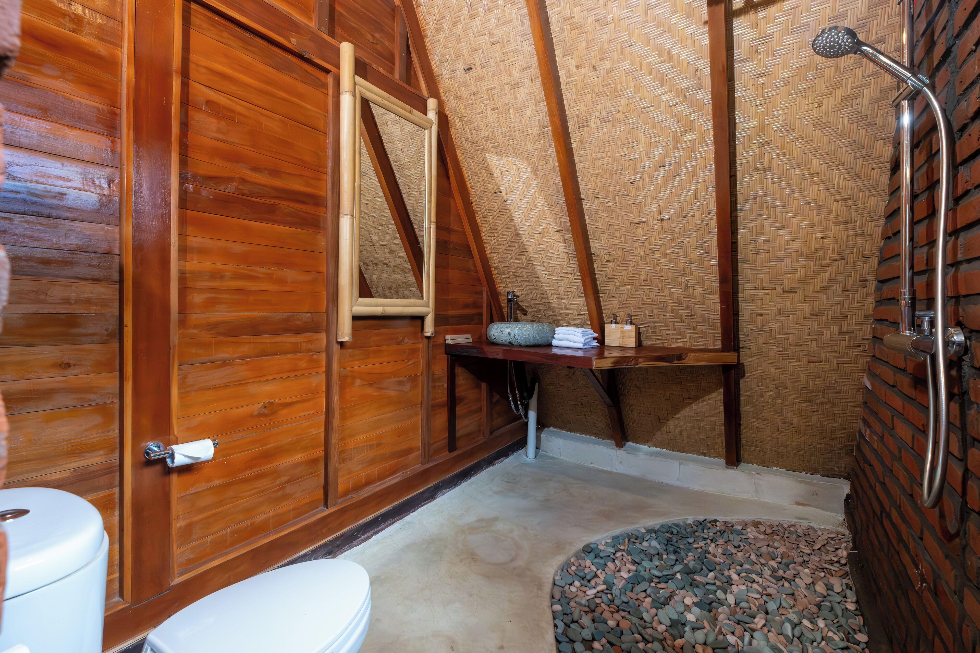 A wooden bathroom with a shower, a toilet, and a sink.
