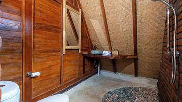 A wooden bathroom with a shower, a toilet, and a sink.