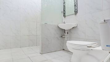 A bathroom with a toilet, sink, and tiled walls.