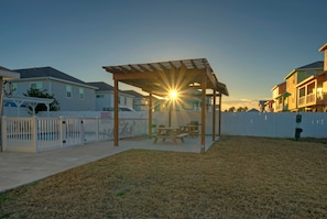 Enjoy a serene outdoor space with a pergola, picnic table, and white picket fence.