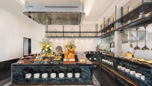 A modern kitchen with marble countertops, a buffet setup, and a chef preparing food. - Kunming Kasion Hotel (Kunming)