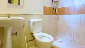 Une salle de bain avec des toilettes, un lavabo et une douche.
