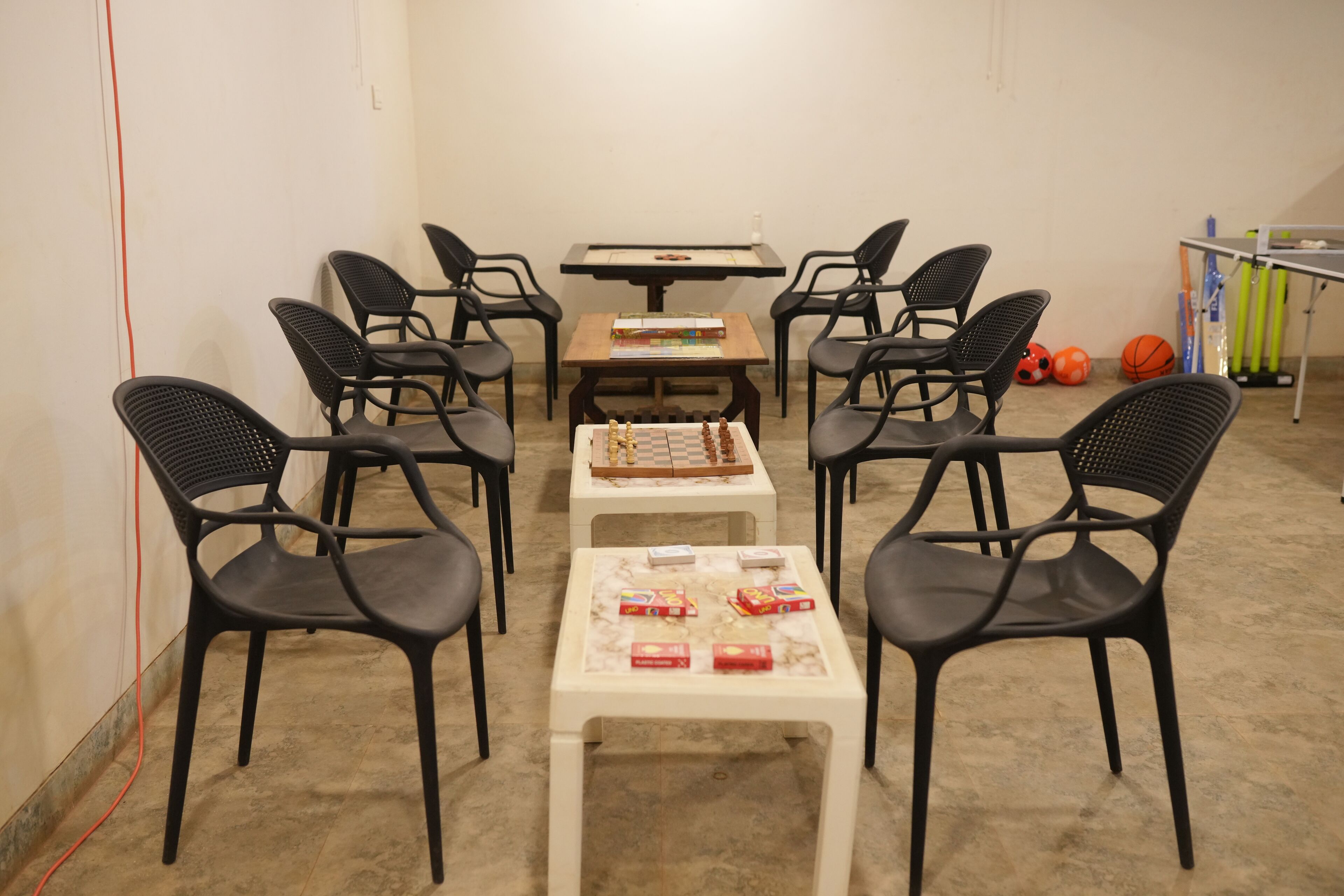 Um quarto com um tabuleiro de xadrez, livros e equipamentos de ginástica.