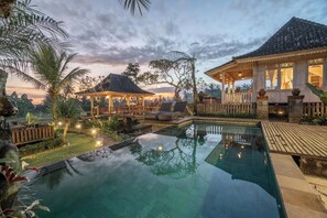Ein ruhiger Poolbereich mit einem Pavillon, Liegestühlen und einer Holzterrasse.