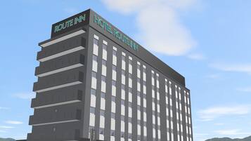 Un grand bâtiment d’hôtel moderne, avec une enseigne indiquant « ROUTE INN HOTEL ROUTE INN ».