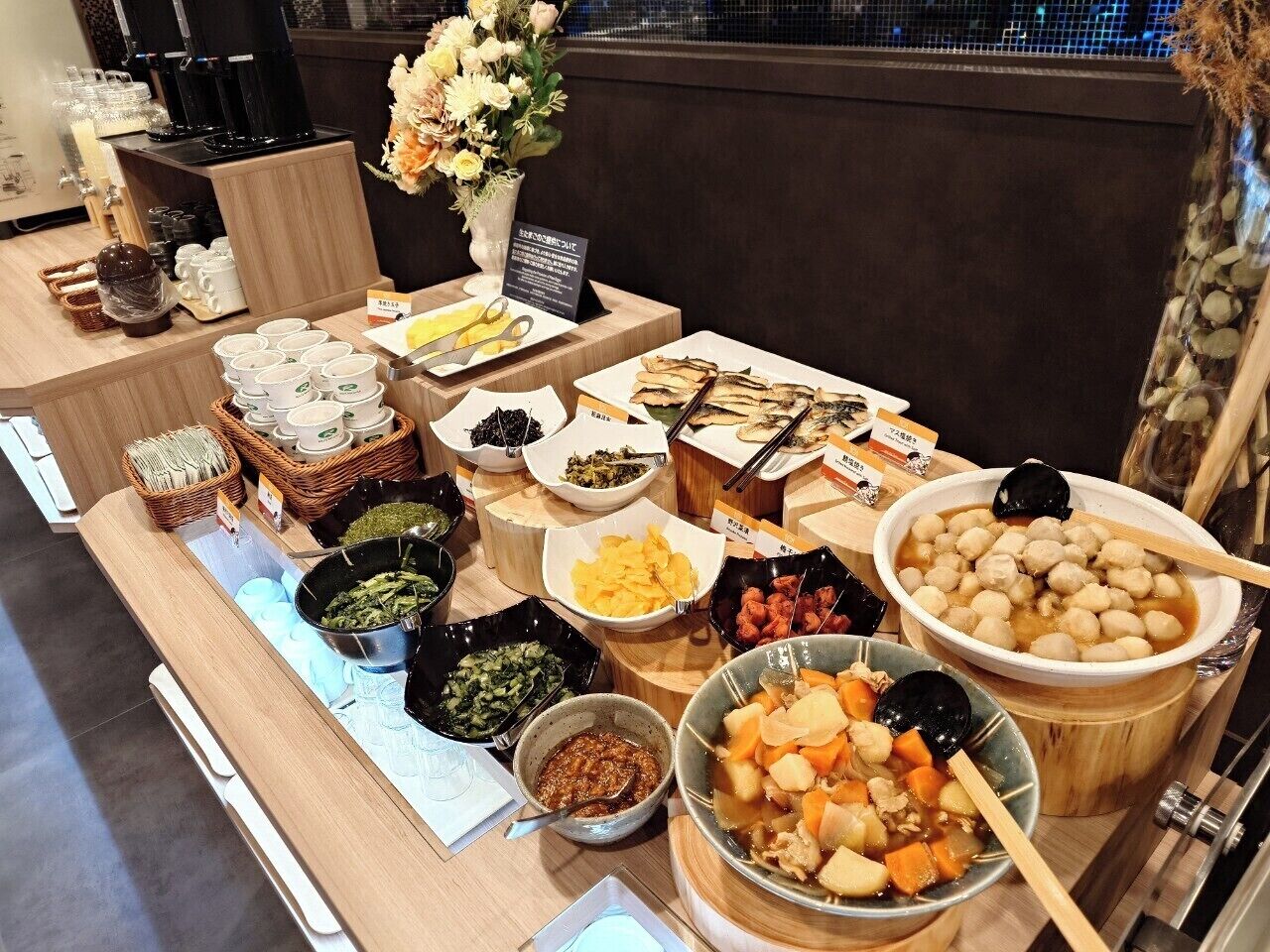 A buffet table with various dishes and condiments.