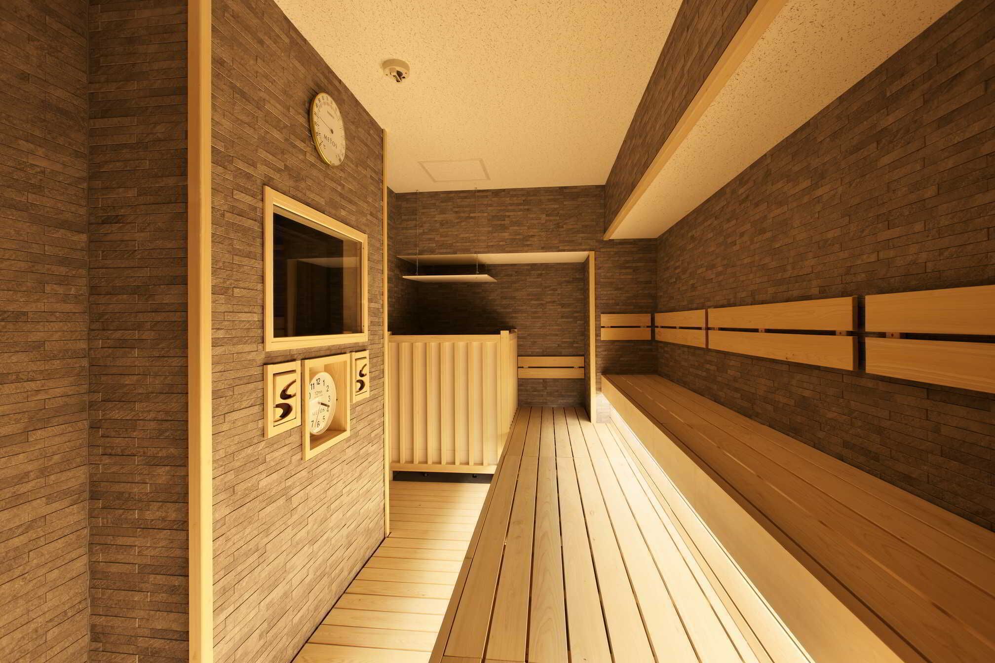 Una sala de sauna con bancos de madera y pared de madera.