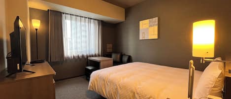 Une chambre d’hôtel équipée d’un lit, d’un bureau, d’une chaise et d’un téléviseur.