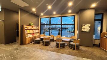 A cozy reading area with a large window, a bookshelf, and comfortable seating.