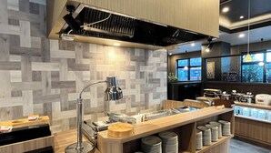 A modern kitchen with a wooden backsplash, stainless steel appliances, and a built-in sink area. - Hotel Route Inn Grand Fukushima Ekimae (Fukushima)
