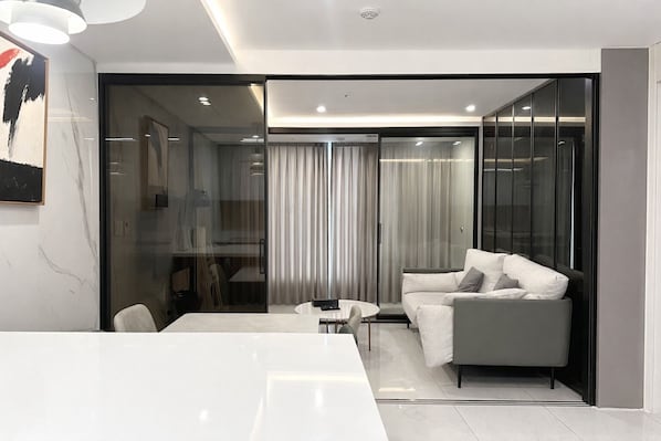 A modern interior with a white table, a grey sofa, and a glass partition. - Zizel Suite Room Seocho (Seoul)