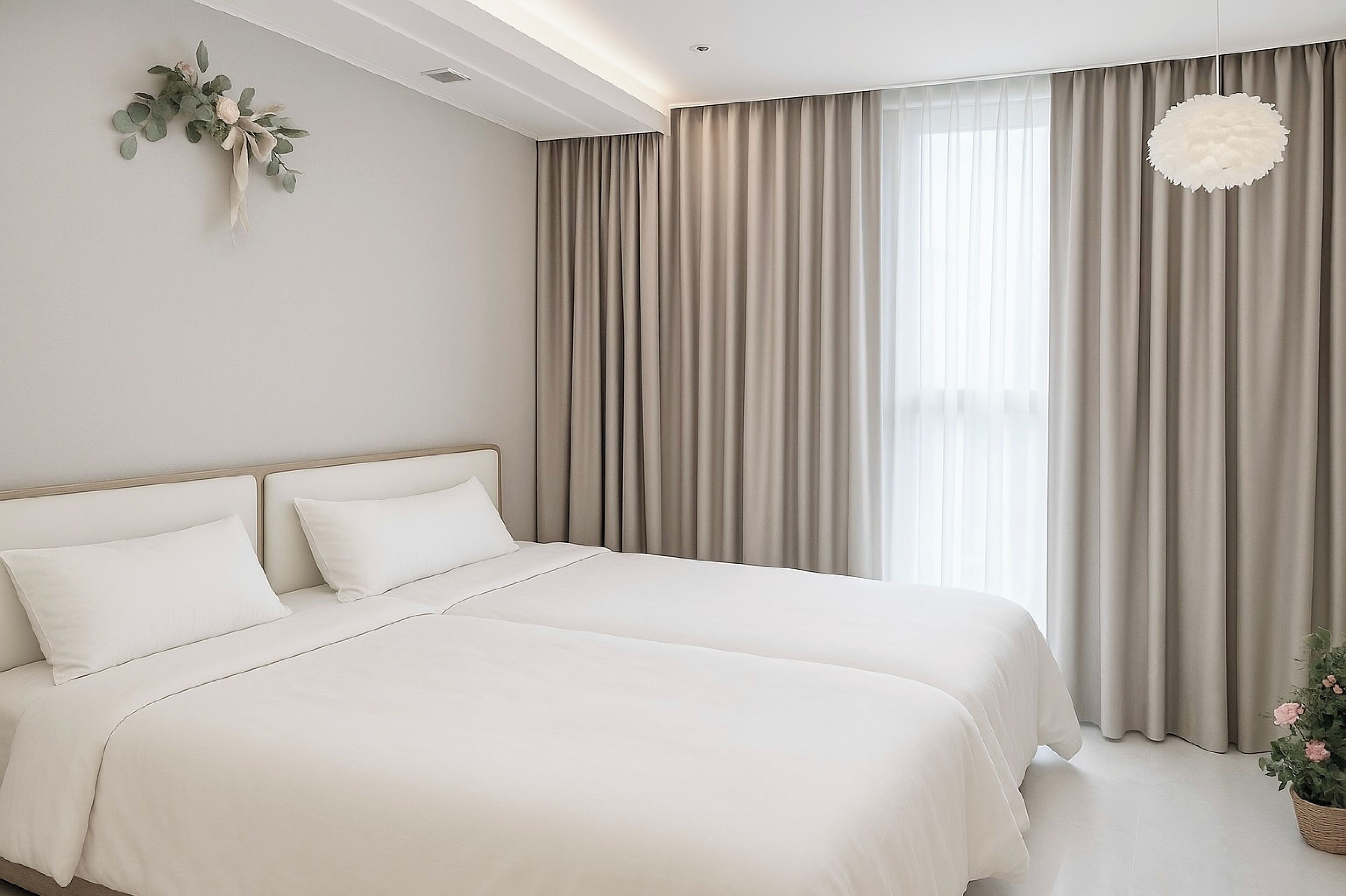 Une chambre moderne avec un grand lit, des rideaux aux couleurs neutres et un élément décoratif mural.