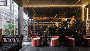 A modern interior with a black marble floor, red upholstered chairs, and a bar area with a decorative globe. - Hotel 433 - Asoke Sukhumvit (Bangkok)