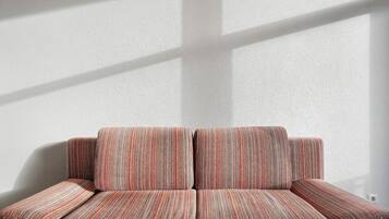 A sofa with a striped pattern against a plain wall.